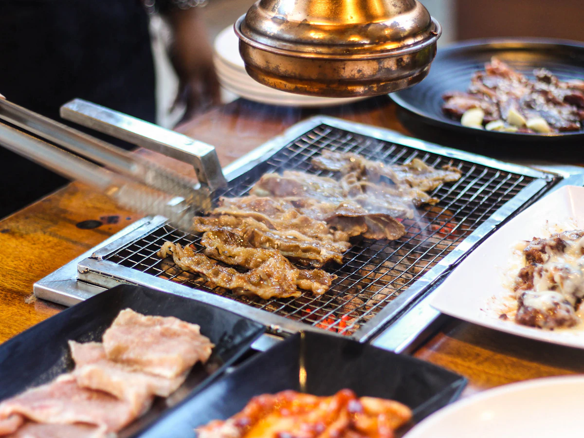 Korean short ribs grilling on a mesh tabletop grill