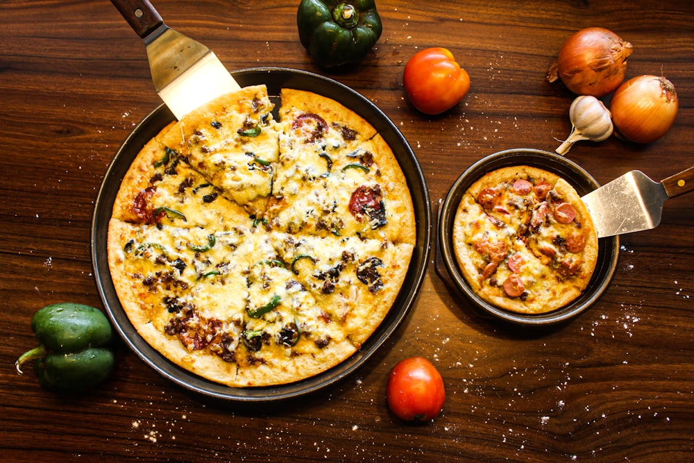 une pizza posée sur une casserole sur une table en bois