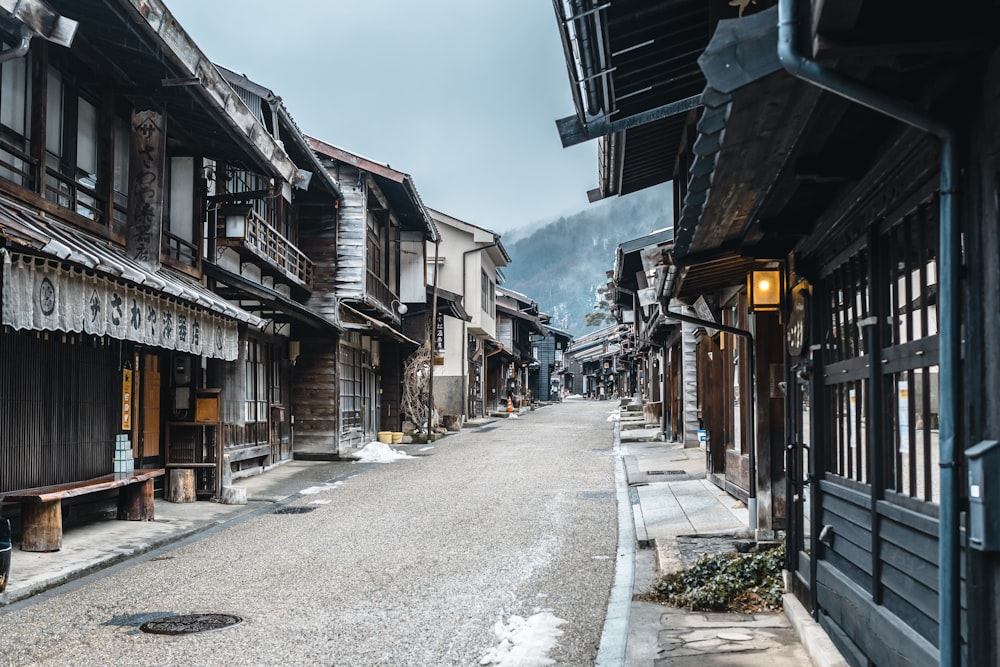 a street lined with wooden buildings with a mountain in the background