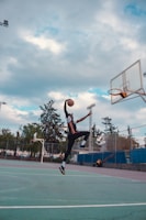 A dynamic basketball player mid-air, about to dunk during a local game.
