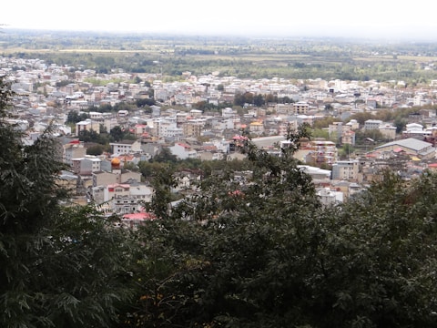 A panoramic view of a sprawling green township with modern buildings and tree-lined streets.