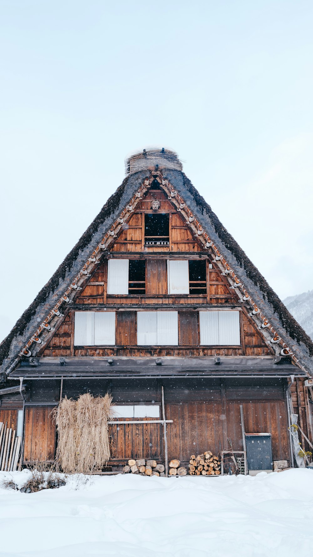 a house with a thatched roof in the snow