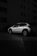 A modern car parked safely with a city backdrop, representing auto insurance