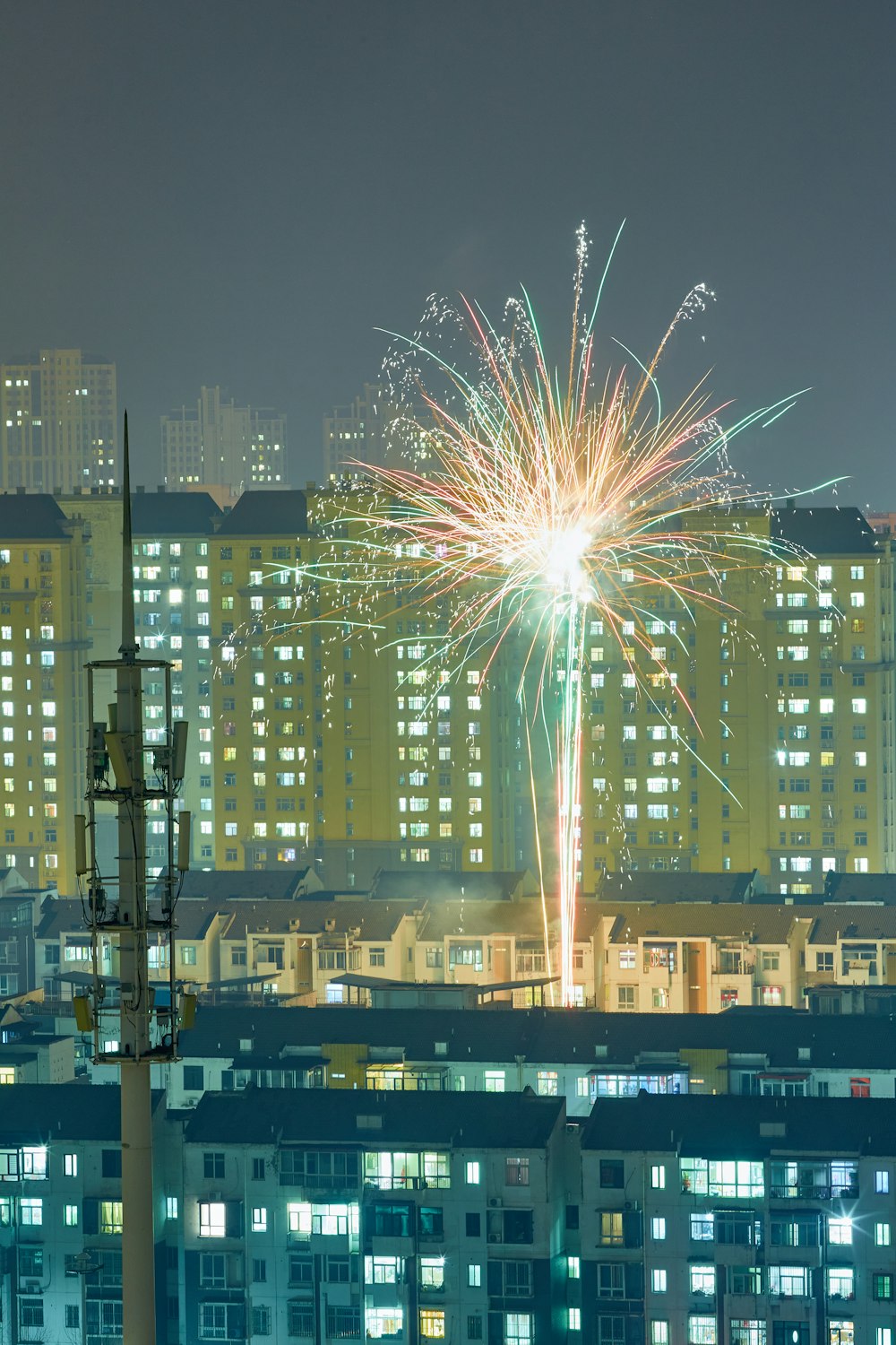 fireworks are lit up in the night sky over a city