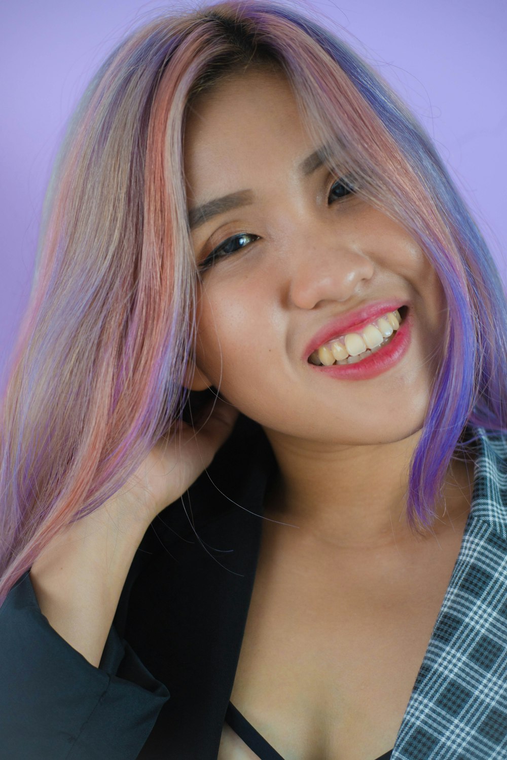 a woman with pink and blue hair smiling