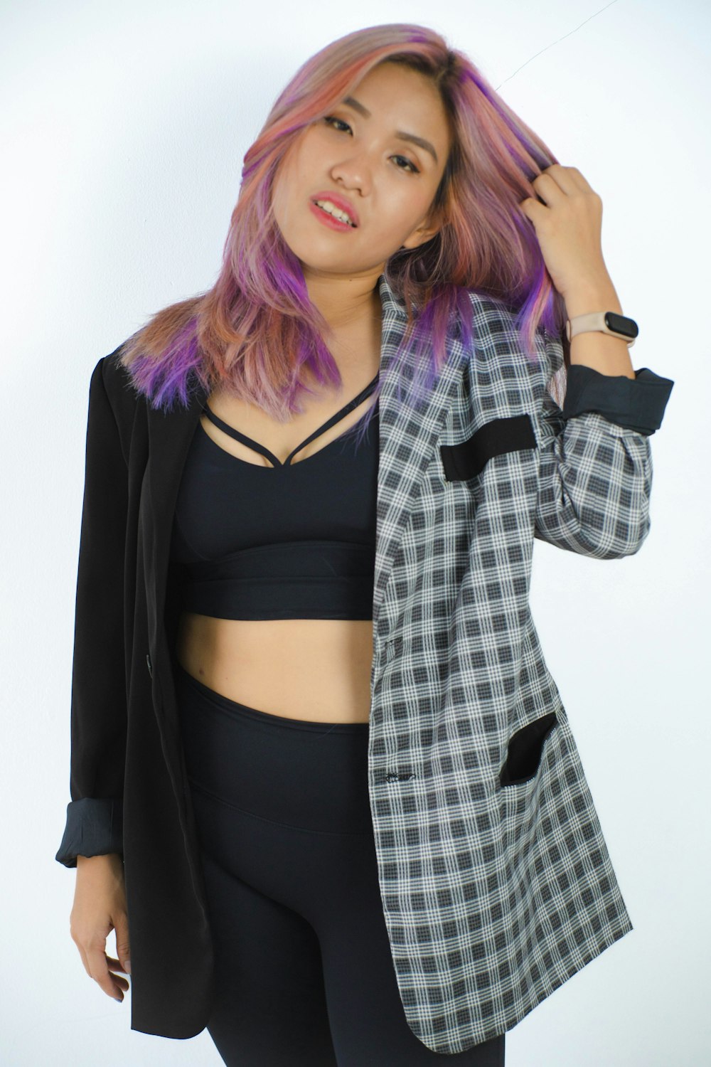 a woman with pink hair wearing a black and white checkered blazer