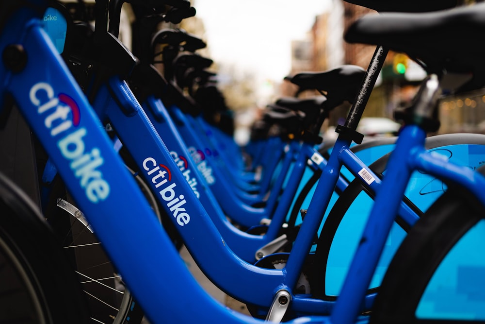 a row of blue bicycles parked next to each other