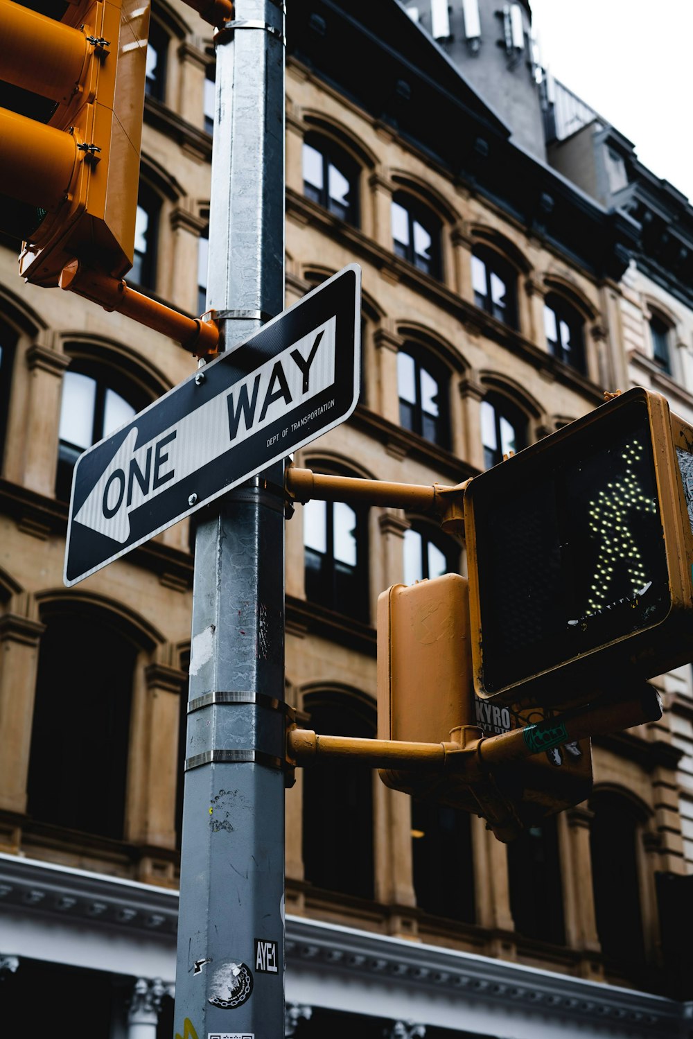 a one way sign on a pole next to a traffic light