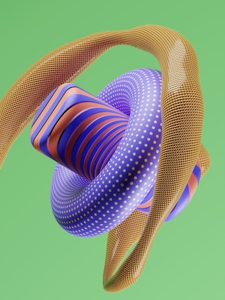 A vibrant 3D abstract sculpture composed of intertwined tubular shapes and geometric forms. The central element is a large, purple torus with white polka dots, surrounded by a spiraling orange and blue striped form. A textured, golden mesh-like structure weaves around the main shapes, set against a flat, solid green background.
