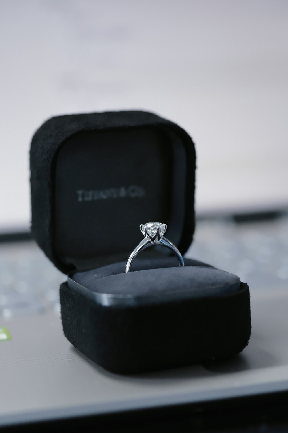 a diamond ring sitting on top of a laptop computer