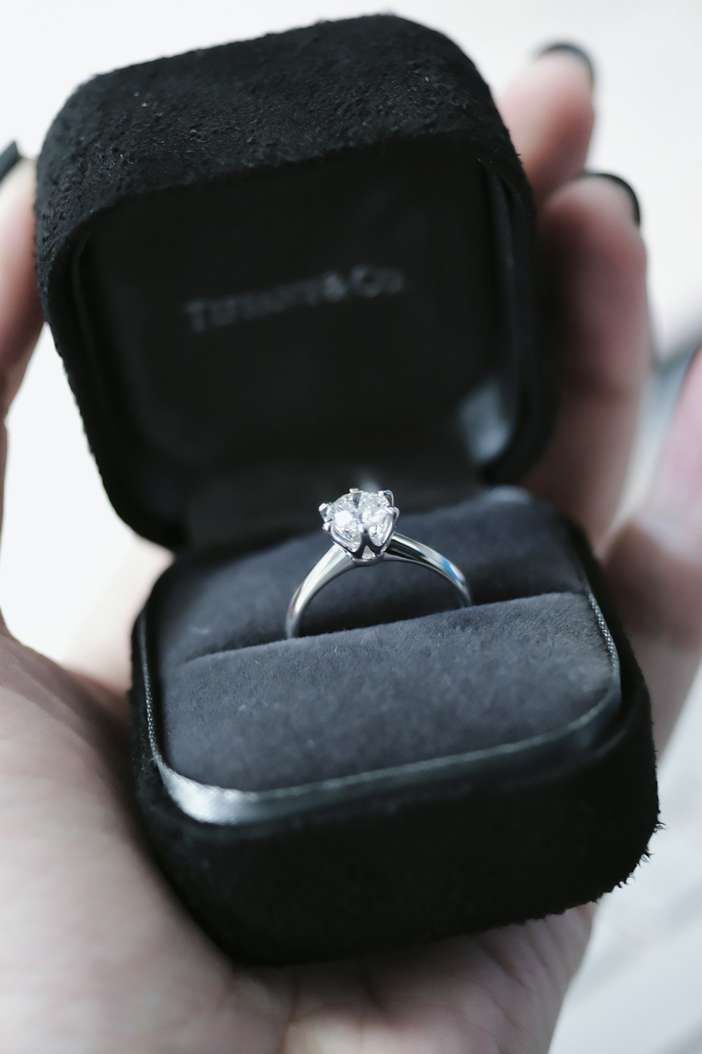 a person holding a ring in a black box