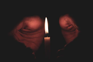 Hands clasped firmly in fellowship within a lodge room bathed in warm candlelight.
