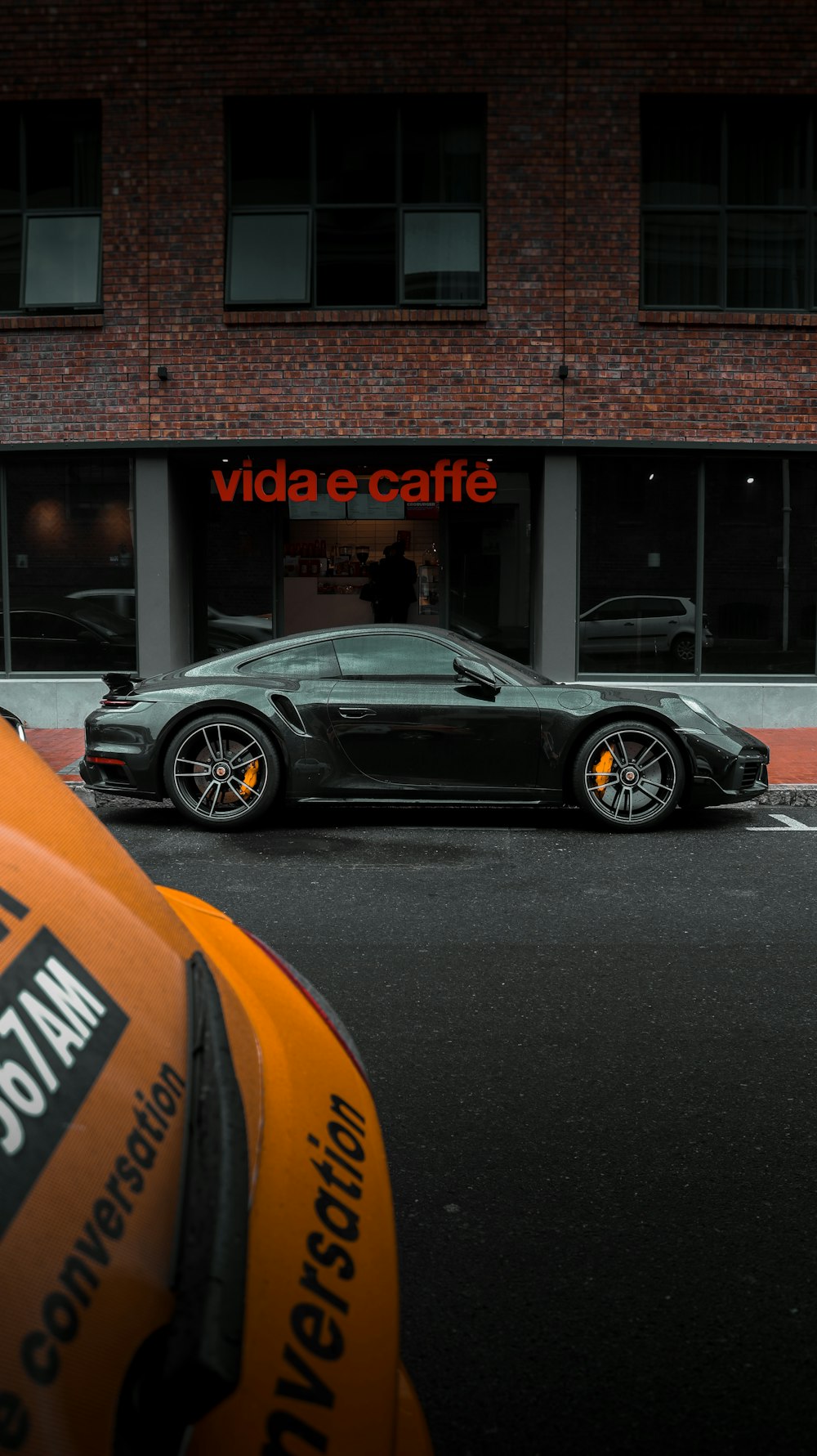 a black sports car parked in front of a cafe