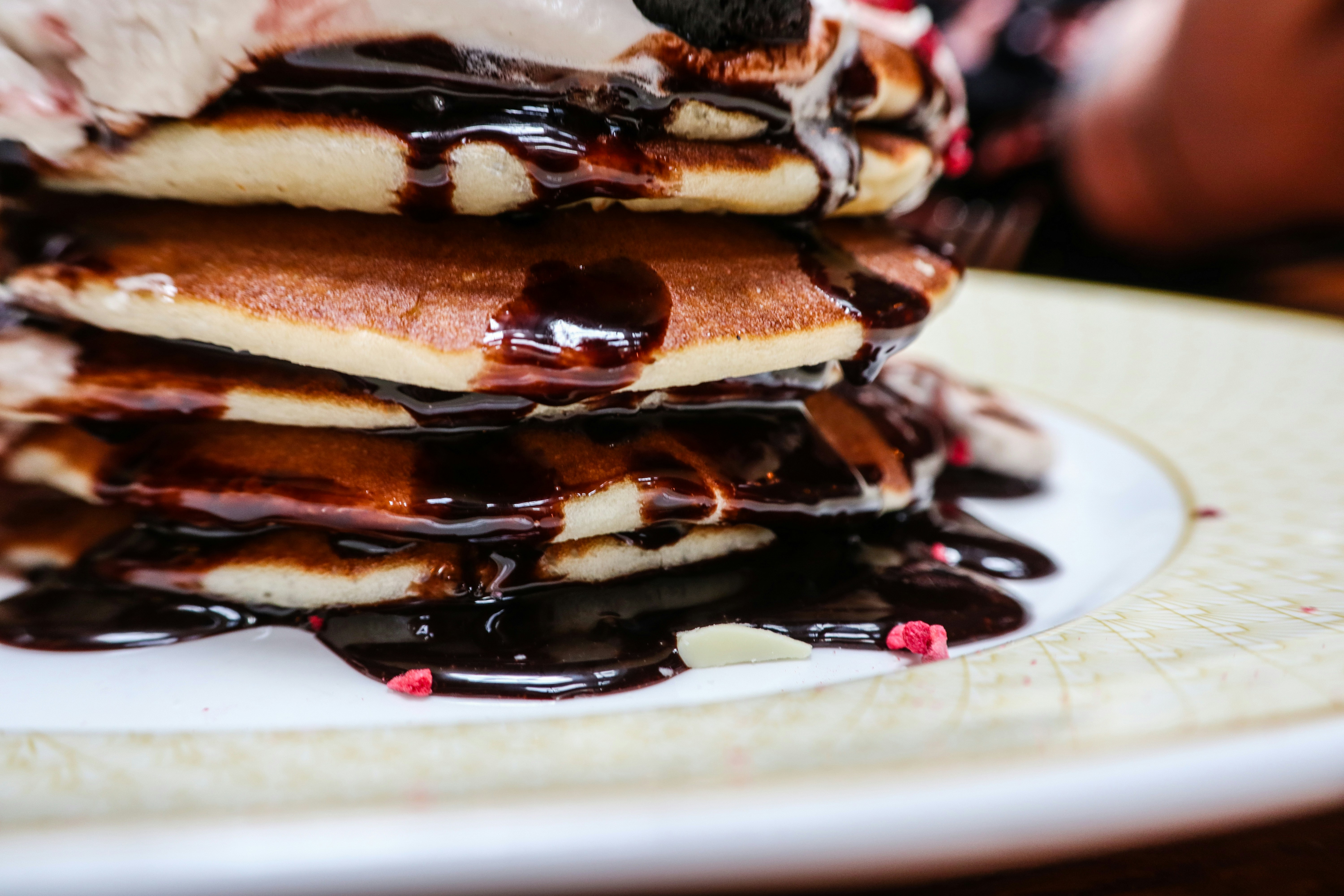 a stack of pancakes covered in chocolate syrup