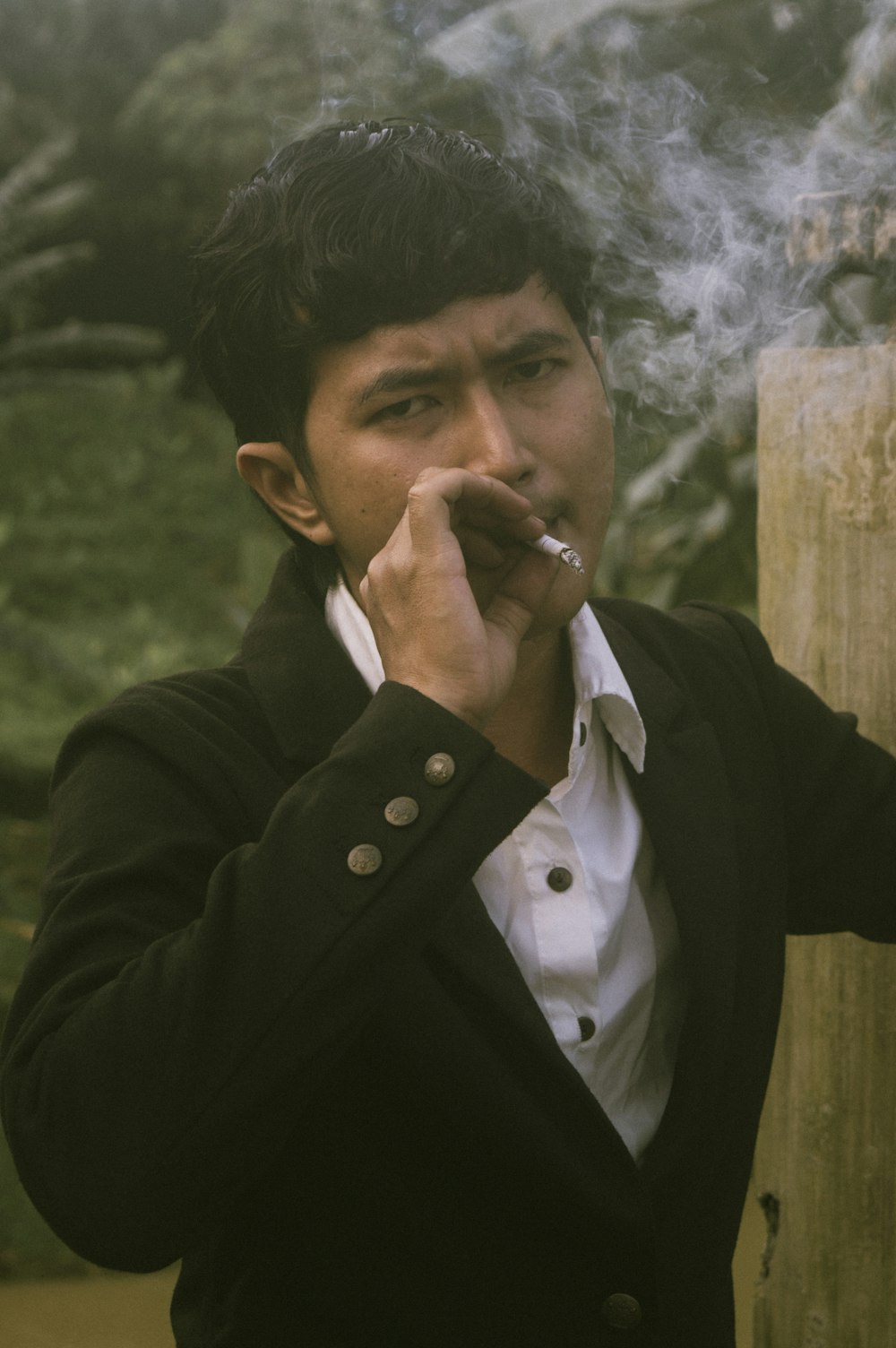 a man in a suit smoking a cigarette