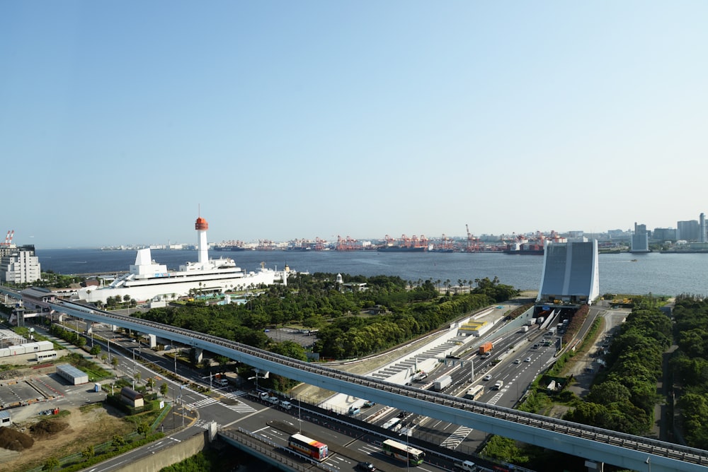 an aerial view of a highway with a cruise ship in the background