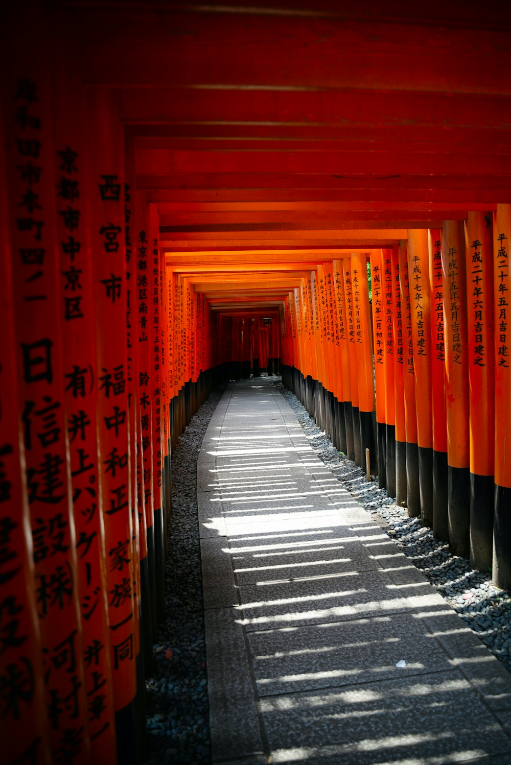 a walkway lined with orange and black columns