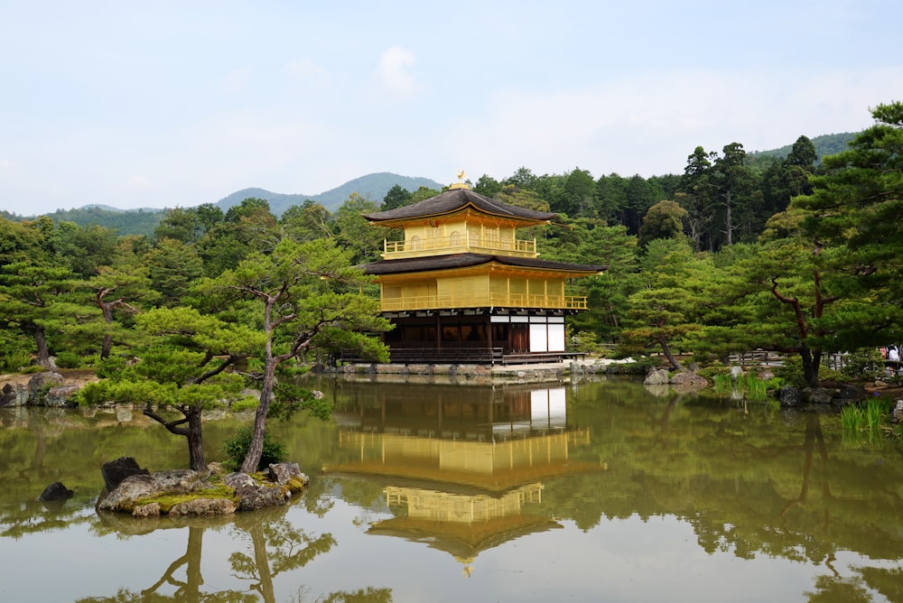 a pagoda in the middle of a pond surrounded by trees