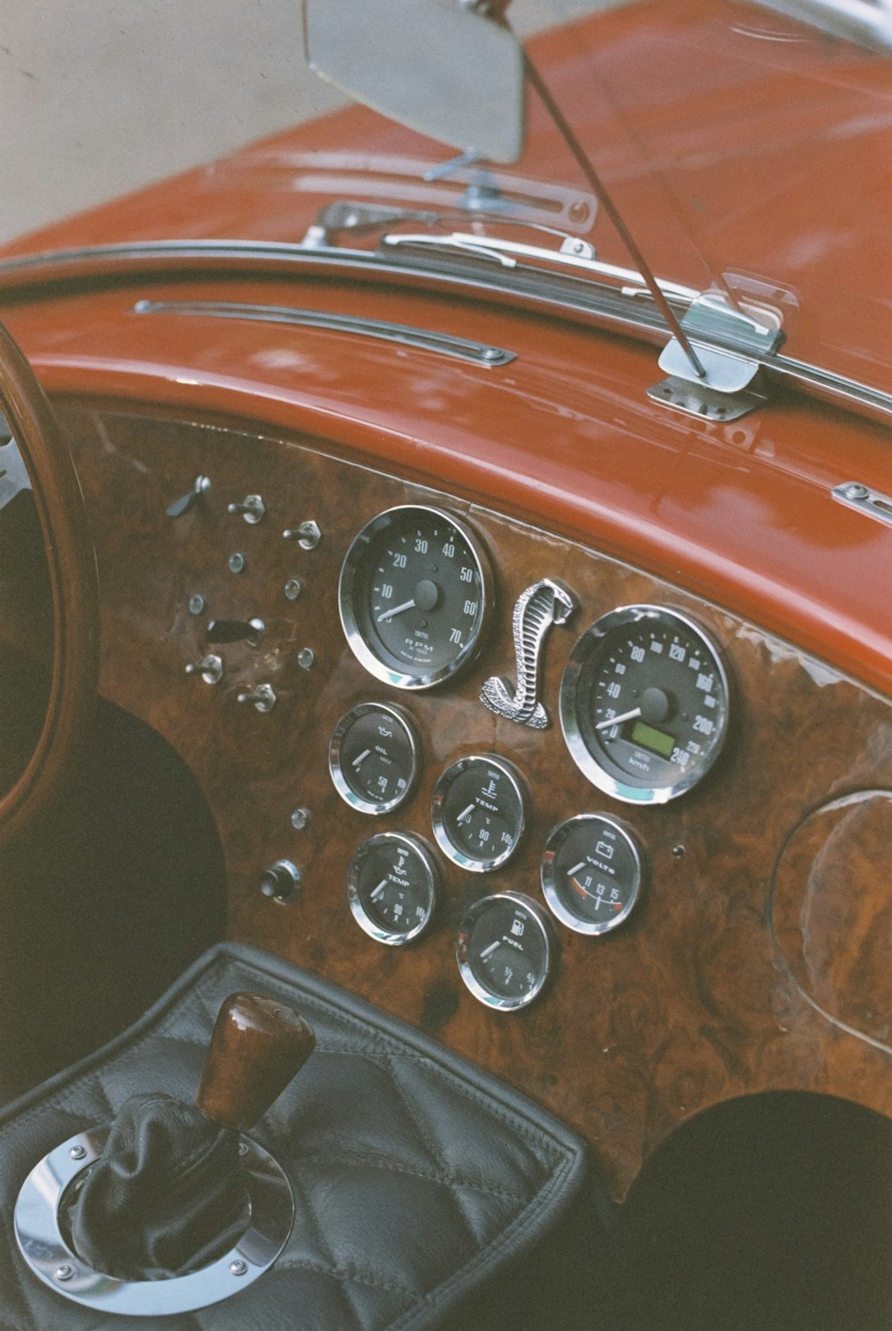 the dashboard of an old car with a wooden panel