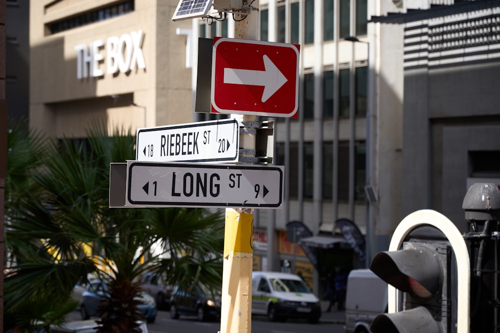 a red and white street sign sitting on the side of a road