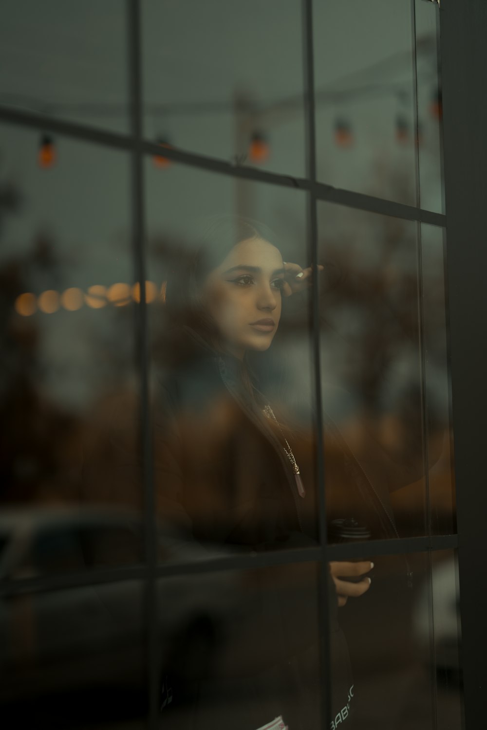 a woman looking out of a window at a car