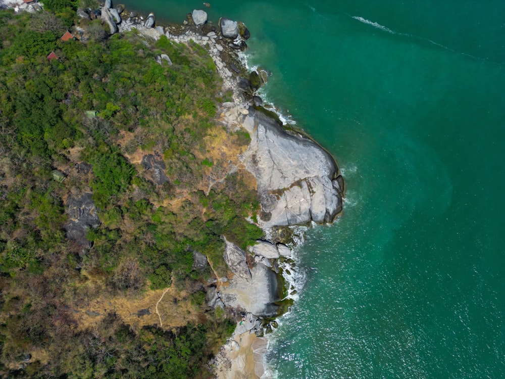 an aerial view of a beach with a boat in the water