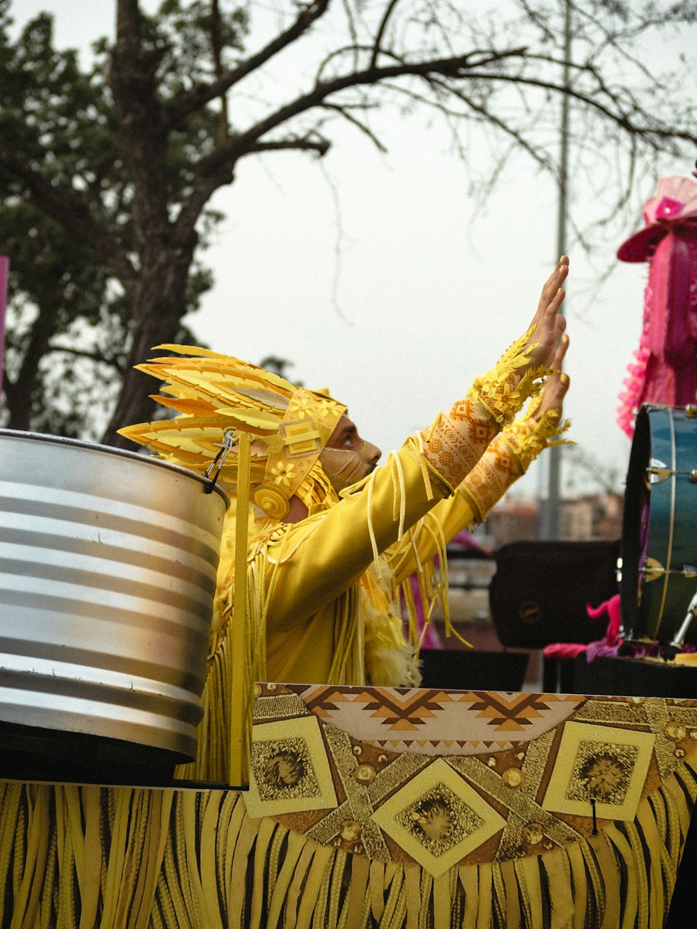 a woman in a yellow outfit holding her hands up