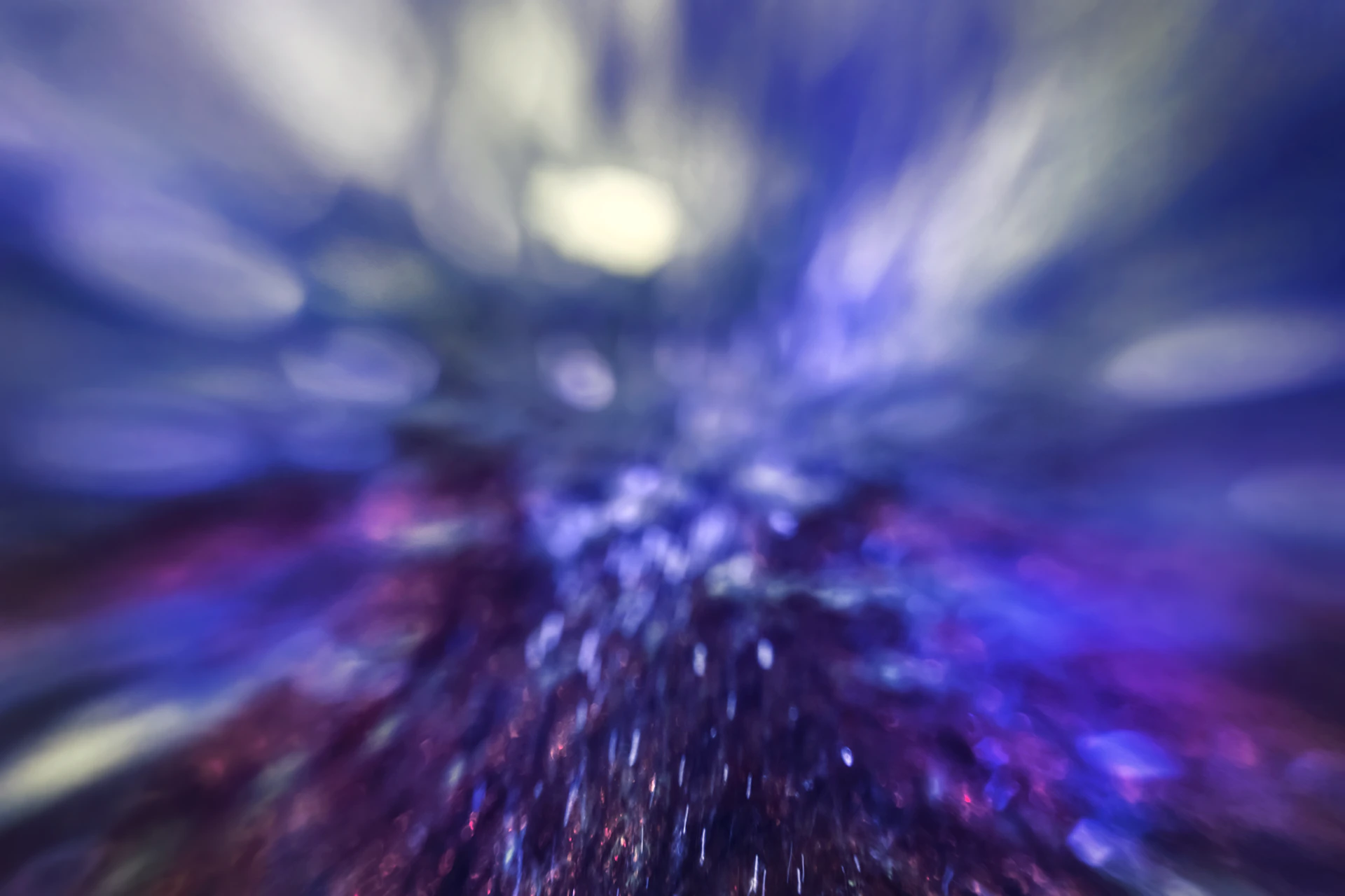 A dynamic photo of Incantoblu revealing a floating object, framed by rich blue and crimson hues.