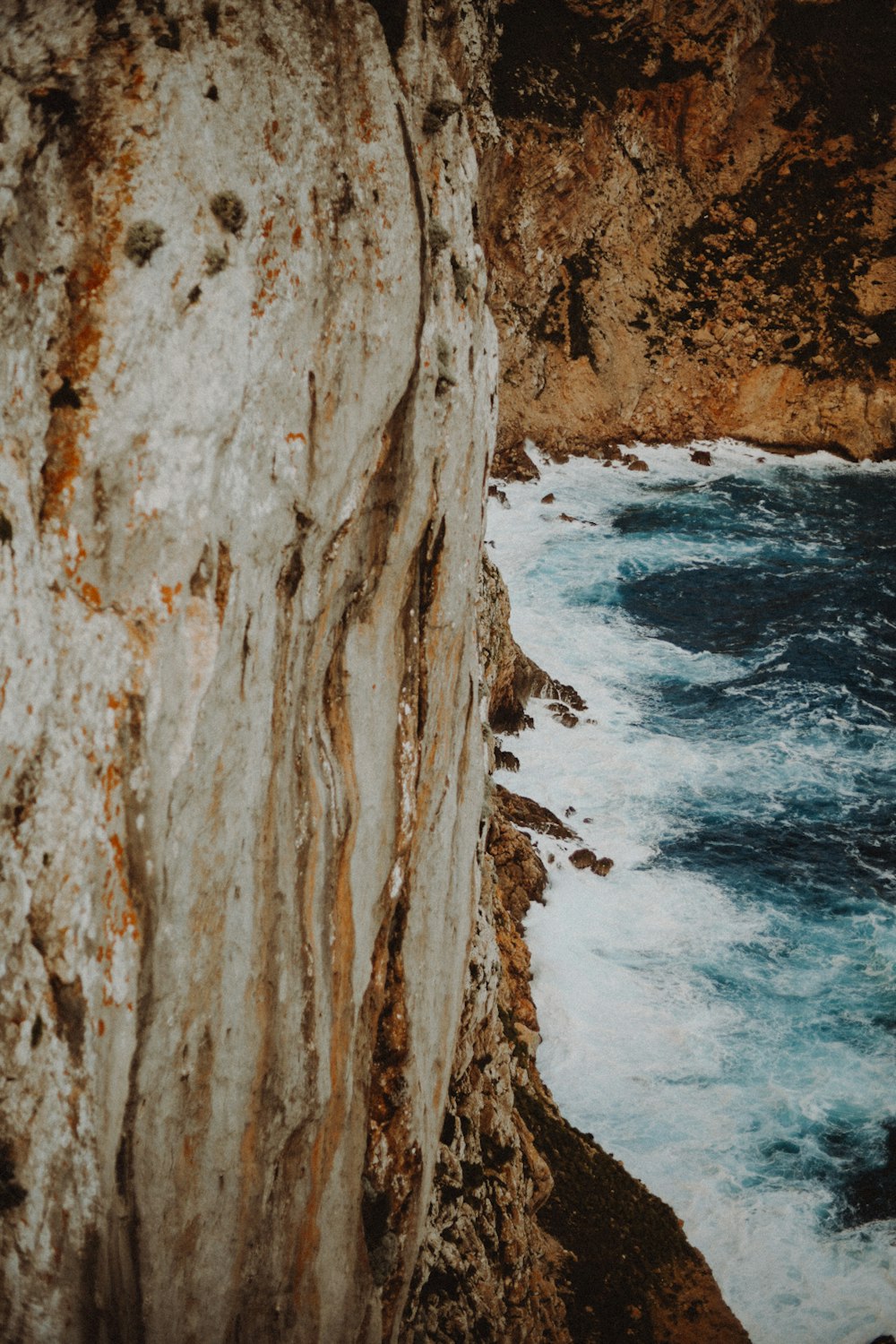 a person standing on top of a cliff near the ocean