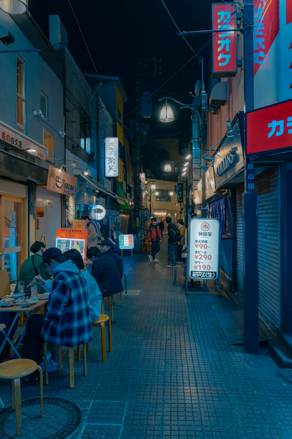 a group of people sitting at a table in an alley