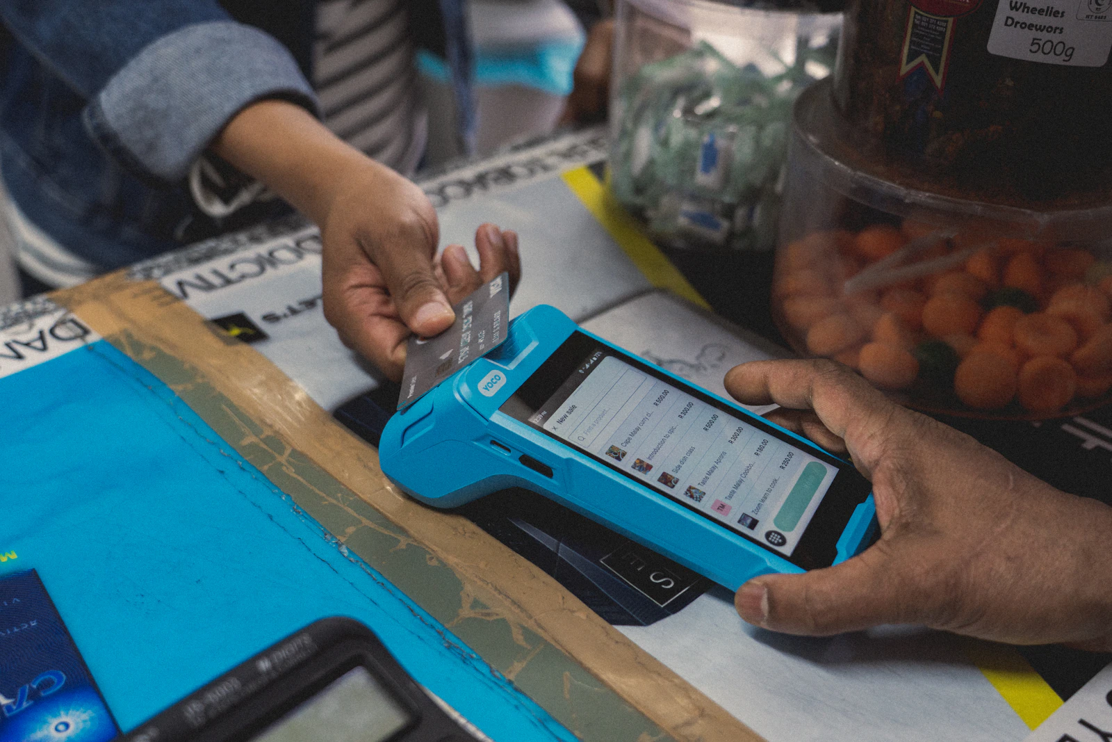 Paiement par carte sur un terminal mobile chez un commerçant, illustration du paiement de proximité.