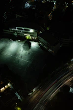 Aerial view of Cancha Vedia illuminated at dusk with players warming up on the field.