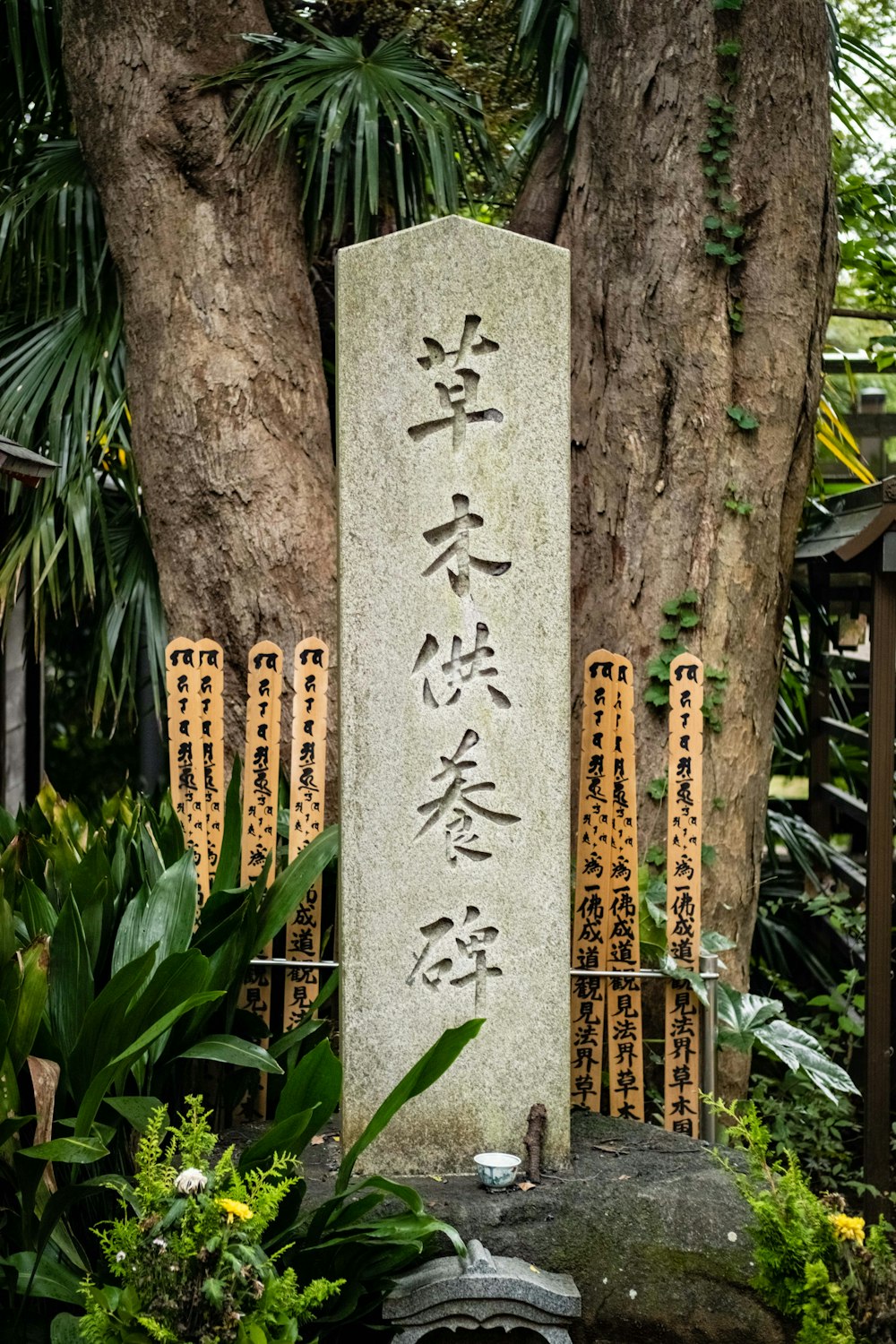a stone with writing on it in front of a tree
