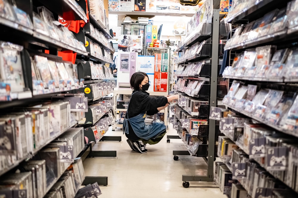 a woman kneeling down in a store aisle