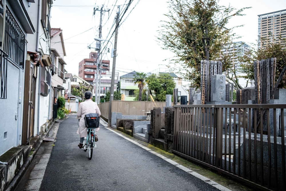 a person riding a bike down a narrow street