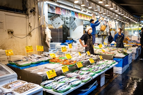A bustling fish market early in the morning with fresh catches on display.