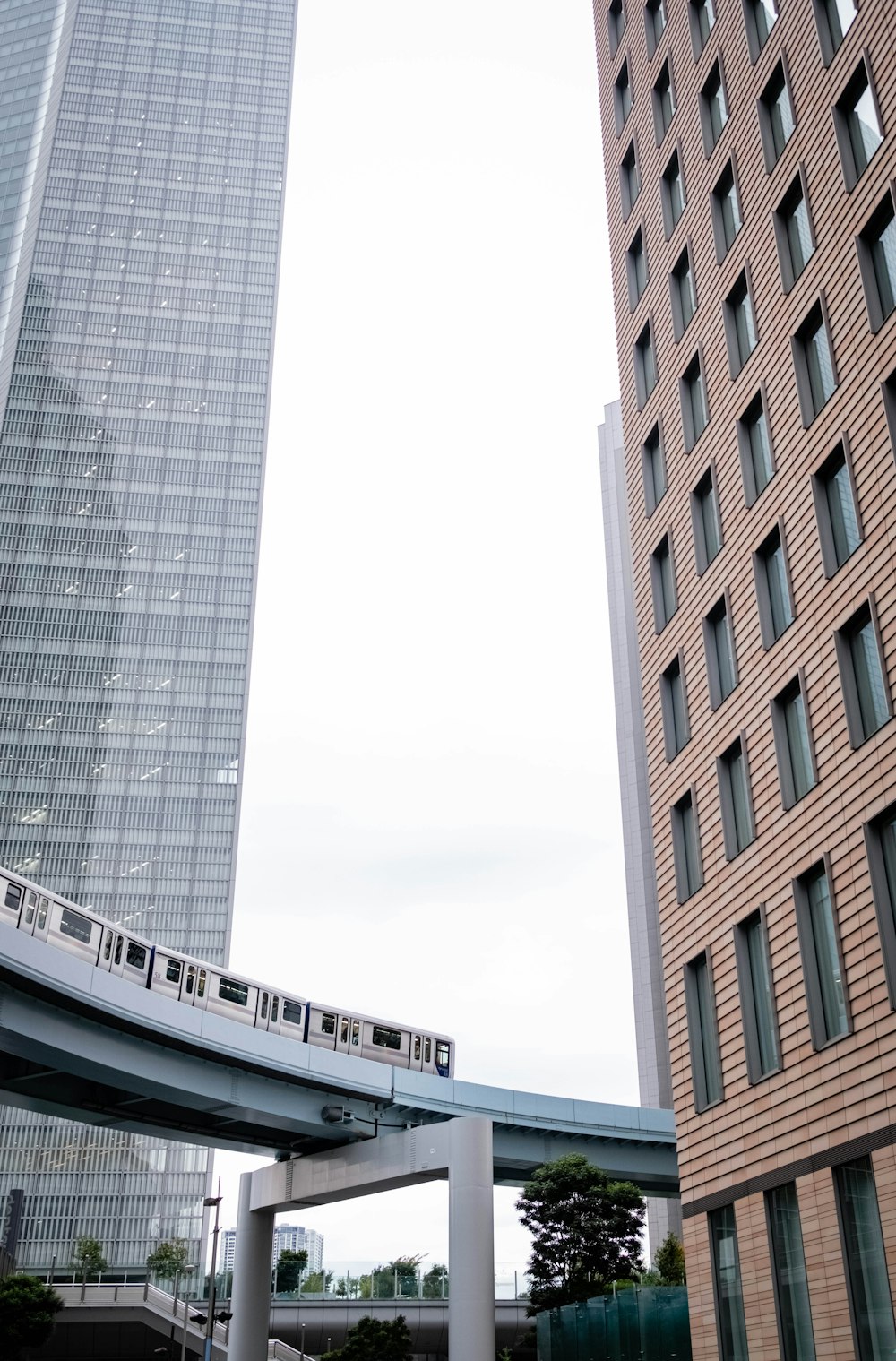 a train traveling over a bridge next to tall buildings