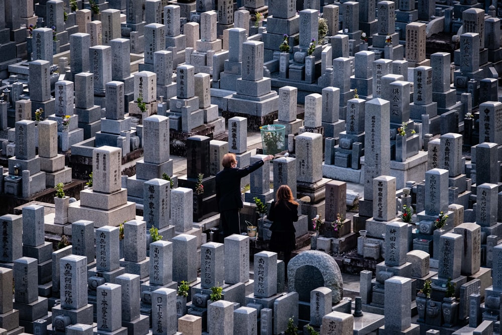 a man and a woman standing in a cemetery