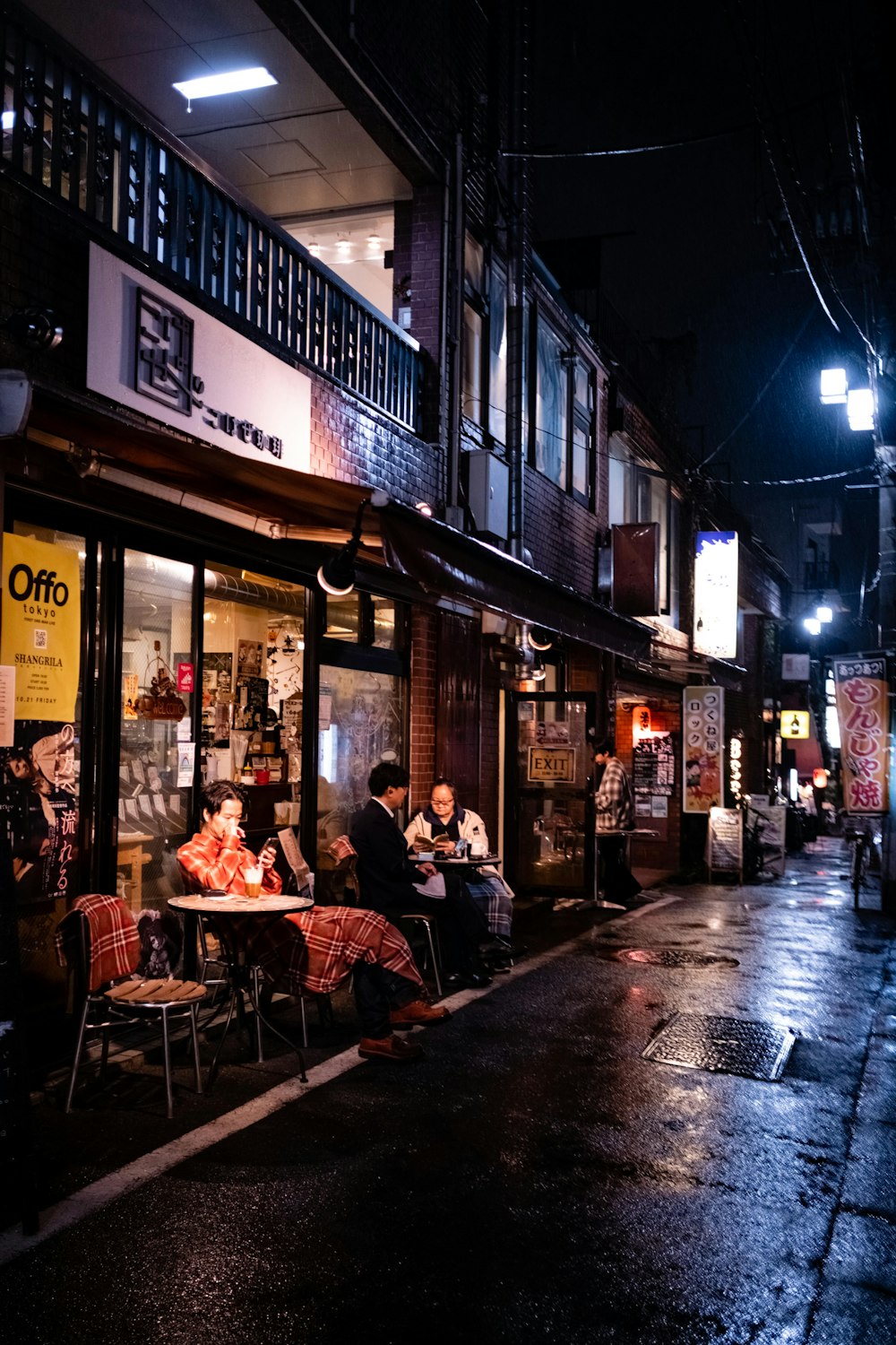 Eine Gruppe von Menschen sitzt an einem Tisch vor einem Restaurant