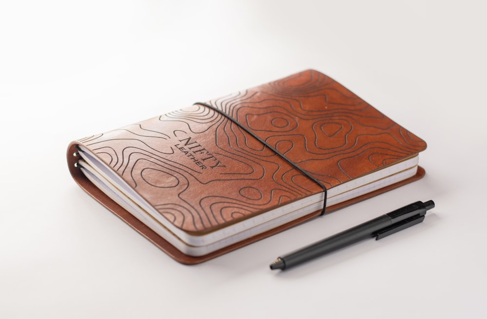 a notebook with a pen on top of it