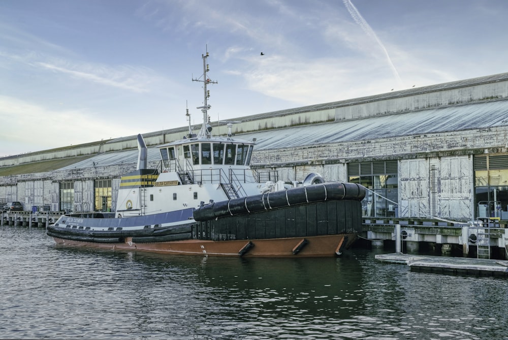 a tug boat docked in a harbor next to a building