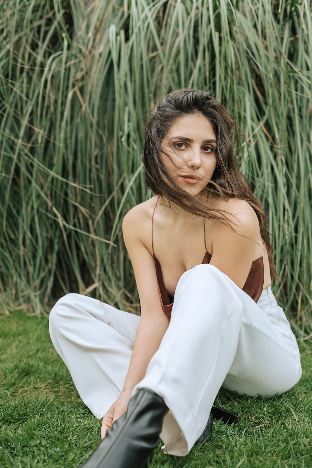 a woman sitting in the grass with her legs crossed