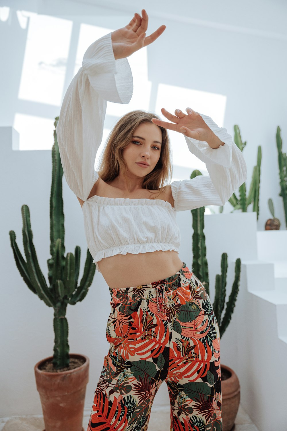 a woman standing in front of a cactus