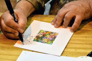 A close-up of hands drawing colorful abstract shapes during an art therapy session.