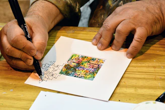A close-up of hands drawing colorful abstract shapes during an art therapy session.