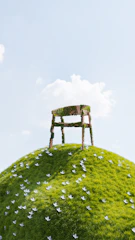 a chair sitting on top of a green hill