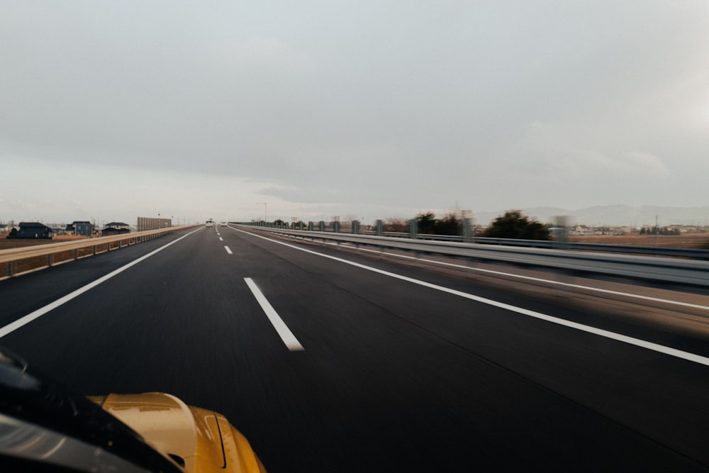 a car driving down a highway with a sky background