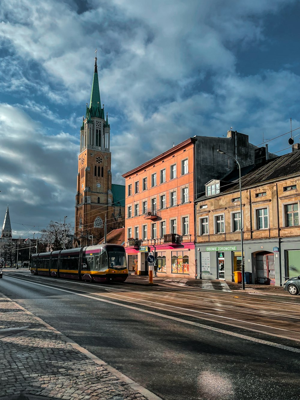 a city street with buildings and a train on the tracks