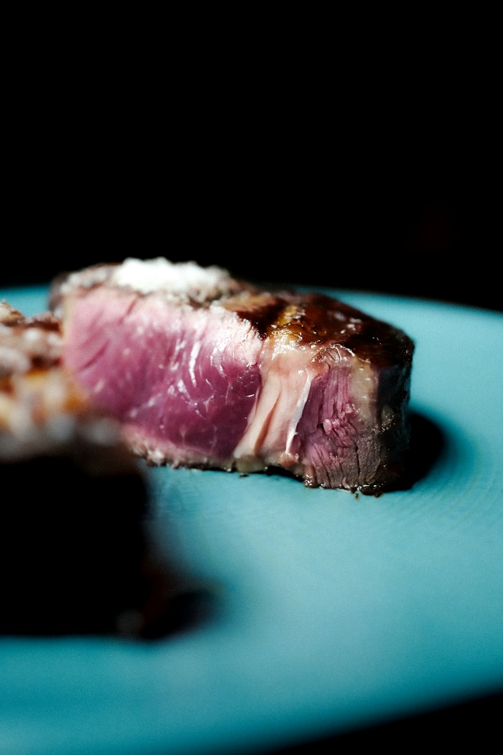 a piece of meat sitting on top of a blue plate