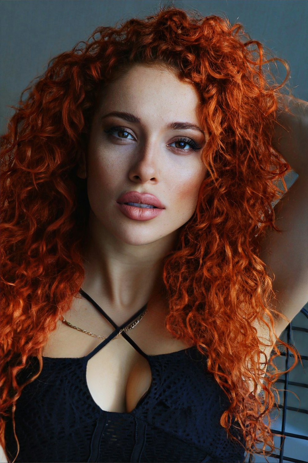 a woman with red curly hair posing for a picture